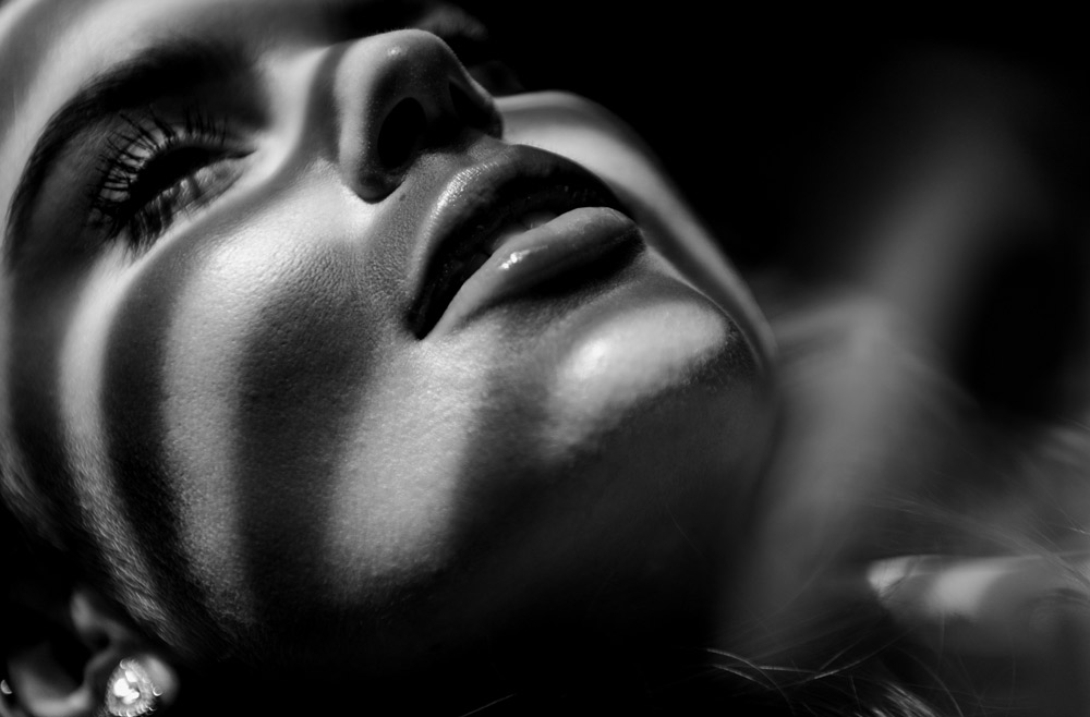 Close-up of woman’s face with smooth skin and defined facial contours in dramatic lighting
